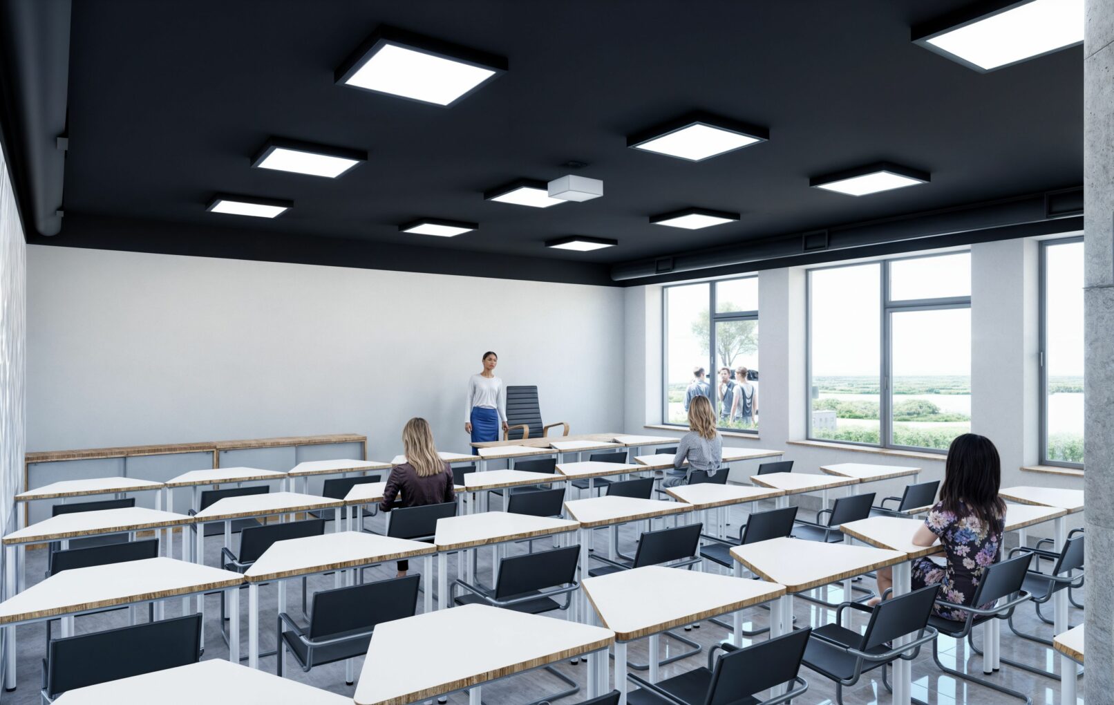 Contemporary classroom with geometric desks and black chairs arranged in neat rows. The space features a dark ceiling with modern square light panels, large windows overlooking greenery, and a female instructor at the front of the room. Several students are seated, with additional people visible outside the window.