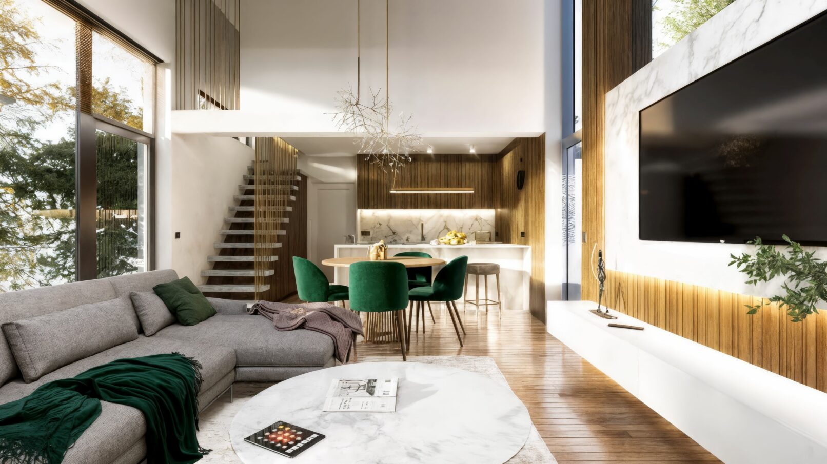 A contemporary open-plan living and dining area featuring double-height ceilings, a marble-accented TV wall, and warm wooden finishes throughout. The space includes a modern grey sectional sofa, emerald green dining chairs, elegant sculptural lighting fixtures, and expansive windows that bring in natural light and forest views. The minimalist kitchen blends marble surfaces with wood textures, creating a refined and inviting interior.