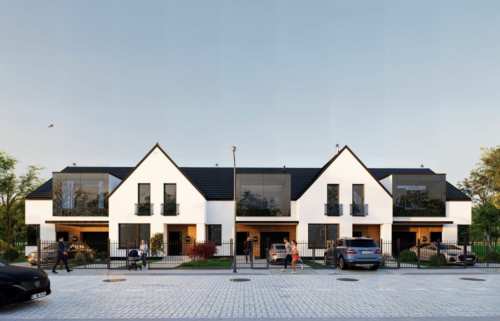 A modern suburban housing development featuring white gable-roofed buildings with dark accents, large windows, and fenced front gardens. The visuals capture different angles of the row houses set against a soft blue sky and cobblestone street with people walking, cars parked, and lush greenery enhancing the residential atmosphere.