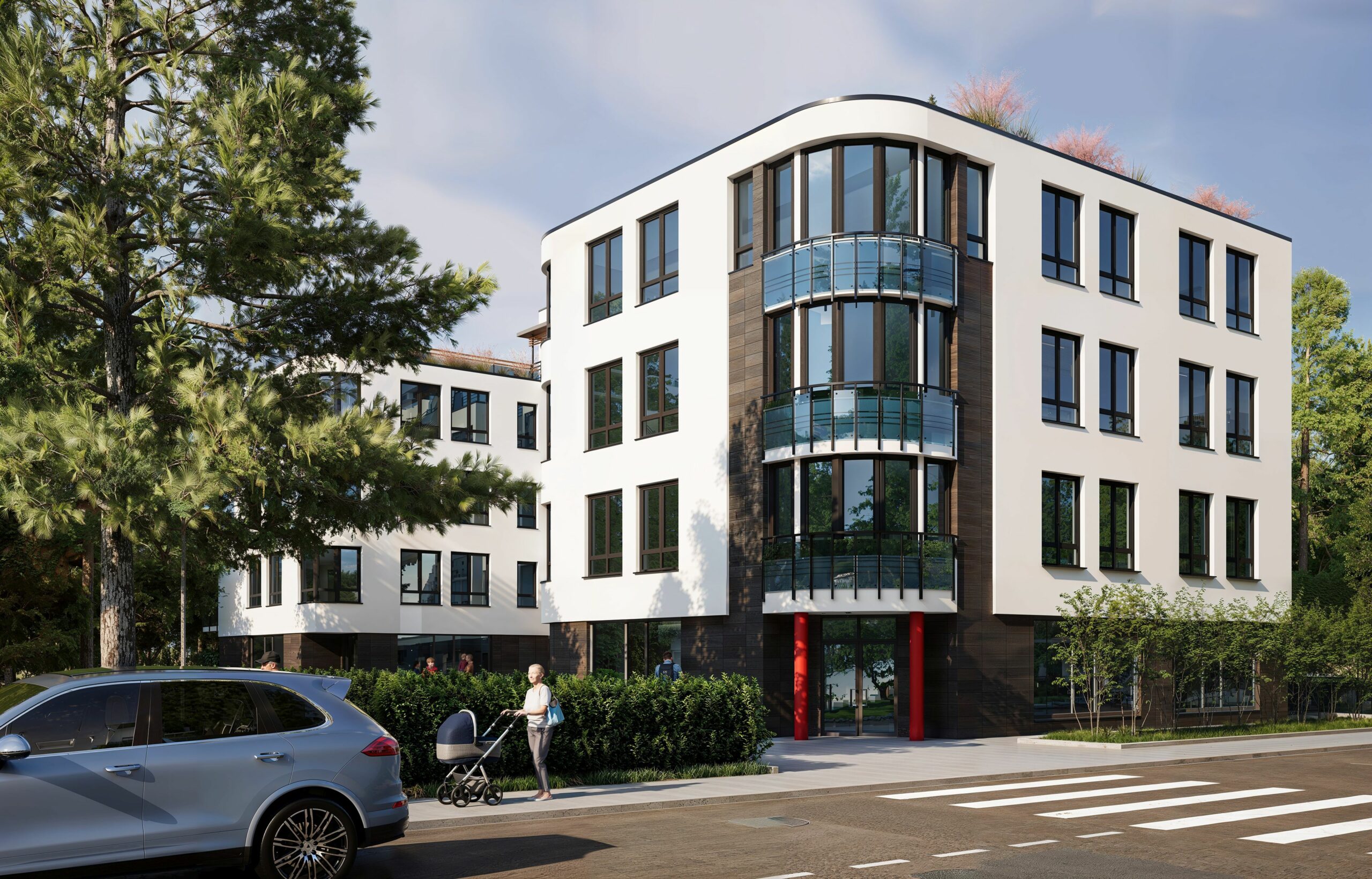 Main façade of Krancowa Residences with curved glass bay windows and vivid red column accents at the entrance.